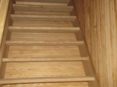 Bel escalier en bois avec des lattes sur les côtés.
