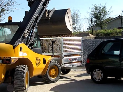Chargement de sable par un bulldozer dans une remorque.